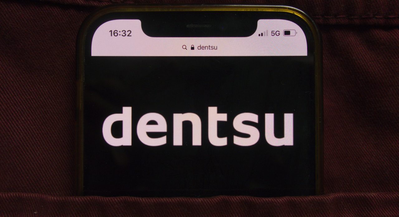 KONSKIE, POLAND - February 22, 2022: Dentsu Group Inc logo displayed on mobile phone hidden in jeans pocket